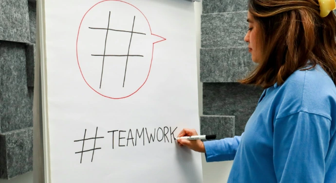 a woman writing on a white board with a marker